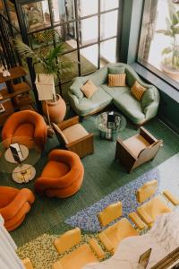 a living room with orange chairs and a couch at Wilde Aparthotels Lisbon Liberdade in Lisbon