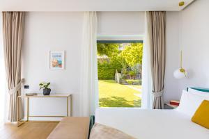 a bedroom with a bed and a large window at Relais Altacosta in Naples