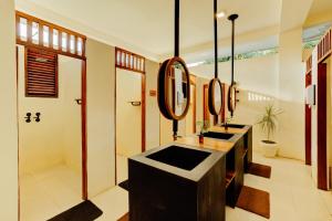 a bathroom with two sinks and a mirror at Malkoha Studios in Dickwella