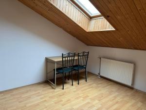 a table and a chair in a room with a skylight at Spacious Rooms Near Center in Ljubljana