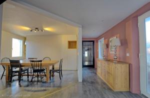 a dining room and kitchen with a table and chairs at Meublés de tourisme Griotte et Cannelle in Bergbieten