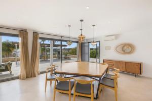 a dining room with a wooden table and chairs at Villa Linda in Punta Prima
