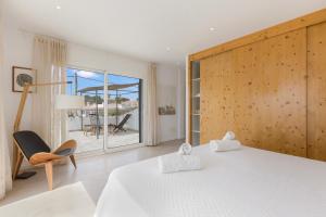 a bedroom with a bed and a chair and a window at Villa Linda in Punta Prima