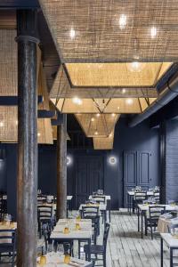 a restaurant with tables and chairs in a room at Palazzo Bellezia Luxury Suites & Spa in Turin