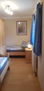 a bedroom with two beds and blue curtains at Ferienhaus Breit in Eppenschlag