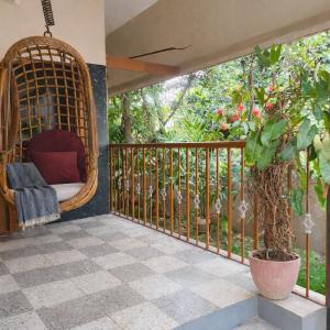 a swing on a porch with a tree at The Timeless Mysuru bungalow in Mysore