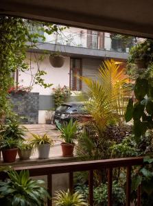 a balcony with a bunch of plants and a car at The Timeless Mysuru bungalow in Mysore