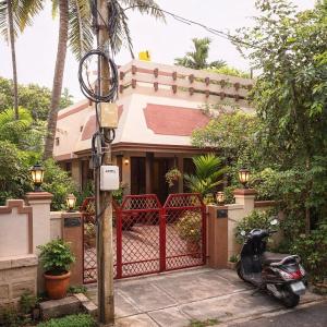a scooter parked in front of a house at The Timeless Mysuru bungalow in Mysore +6 photos