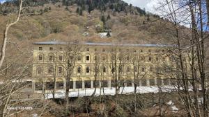 a large stone building with a mountain in the background at LOU CANTUN D'ENDON in Andonno