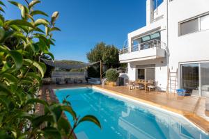 a swimming pool in front of a house at Evaeri villa in Artemida
