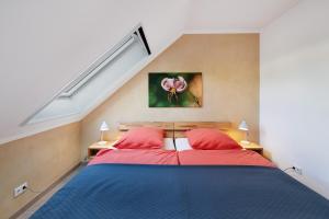 two beds with red pillows in a bedroom at Leben am Weinberg in Herbstein