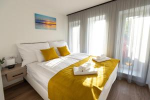 a bedroom with a large bed with towels on it at Pelso Lodge Alsóörs in Alsóörs