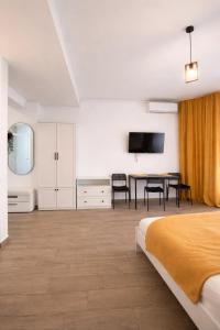 a bedroom with a bed and a desk and a television at Ametist in Mamaia