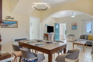 a dining room and living room with a table and chairs at Aegean Villas Ios in Ios Chora