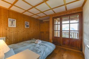 a bedroom with a bed in a room with a window at Gabbro-Chalet Moderne Tout Confort in Villard-Reculas