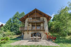 a large house with a balcony on a wooden deck at Gabbro-Chalet Moderne Tout Confort in Villard-Reculas