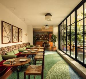 a restaurant with tables and chairs and windows at Wilde Aparthotels Lisbon Liberdade in Lisbon