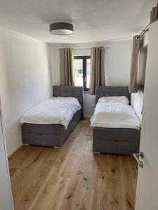 two beds in a room with wooden floors at Fewo Matzing - beim Gartner in Matzing