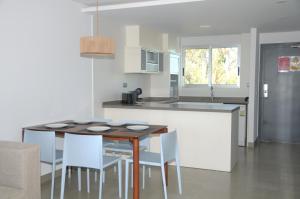 a kitchen with a table and chairs in a kitchen at Apartamentos Bravosol in Denia