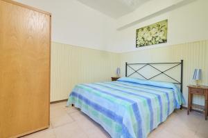 a bedroom with a bed with a blue and white blanket at Mare Etrusco 4 in Populonia