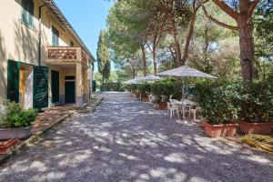 a patio with tables and umbrellas next to a building at Mare Etrusco 4 in Populonia +15 photos