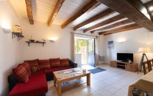 a living room with a red couch and a table at Domaine de Lestroué - Île de Groix in La Vraie-Croix