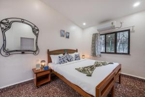 a bedroom with a large bed and a mirror at SaffronStays Sparrow's Nest in Mahabaleshwar
