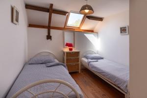 two twin beds in a room with a window at Domaine de Lestroué - Île de Groix in La Vraie-Croix +12 photos