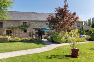 a stone house with a tree in the yard at Domaine de Lestroué - Île de Groix in La Vraie-Croix