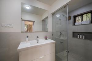 a white bathroom with a sink and a shower at SaffronStays Sparrow's Nest in Mahabaleshwar +25 photos