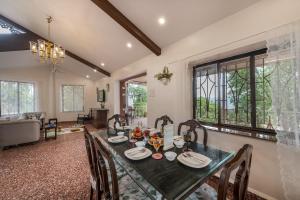 a dining room with a table and chairs at SaffronStays Sparrow's Nest in Mahabaleshwar