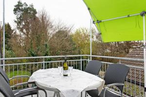 a white table with a bottle of wine on a balcony at Fewo Walk in Salem