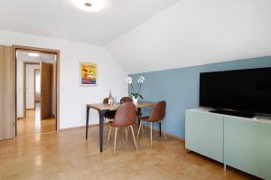 a dining room with a table and chairs and a television at Fewo Walk in Salem
