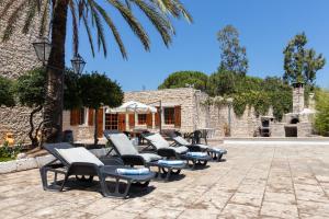 a row of chaise lounge chairs in a courtyard at Torre Cappavecchia in Molfetta