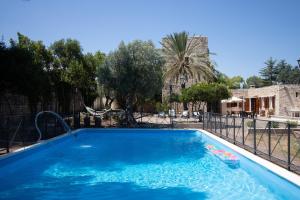 a swimming pool with blue water in a yard at Torre Cappavecchia in Molfetta