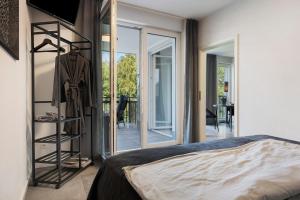 a bedroom with a bed and sliding glass doors at Egge Resort 7e mit Whirpool u Sauna in Altenbeken