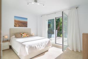 a white bedroom with a bed and a balcony at Villa Jazmin in Mijas Costa +24 photos