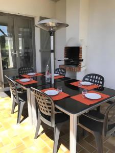 a dining room with a black table and chairs at Le Nid Marin - 76 in Pornic