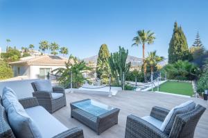 a patio with wicker chairs and a glass table at Villa Jazmin in Mijas Costa