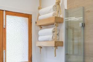 a stack of towels in a bathroom next to a shower at S'escodra in Llucmajor +17 photos