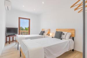 a living room with two beds and a television at S'escodra in Llucmajor