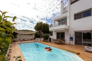 a couple in a swimming pool in a house at Evaeri villa in Artemida