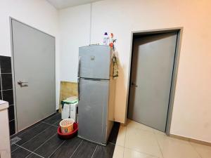 a kitchen with a refrigerator next to two doors at Pitstop Homestay Klia in Banting