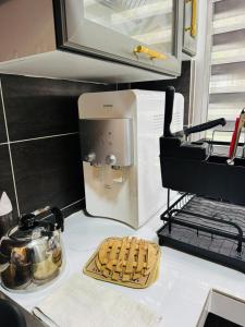 a kitchen counter with a microwave oven and some cookies at Pitstop Homestay Klia in Banting +4 photos