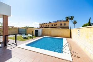 a swimming pool in the backyard of a house at Luisa 3 in Conil de la Frontera