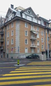 duży ceglany budynek z samochodem zaparkowanym przed nim w obiekcie Junior Suite Apartment by Livingdowntown w Zurychu