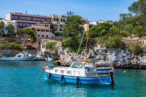 a blue and white boat sitting in the water at Na Pallissera in Santanyi