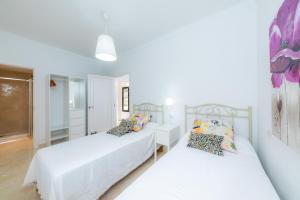 two beds in a bedroom with white walls at Na Pallissera in Santanyi