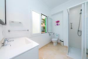 a white bathroom with a sink and a toilet at Na Pallissera in Santanyi +23 photos
