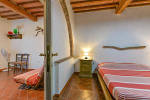 a bedroom with a bed and a table and a chair at Agriturismo Amandolo in Cavo